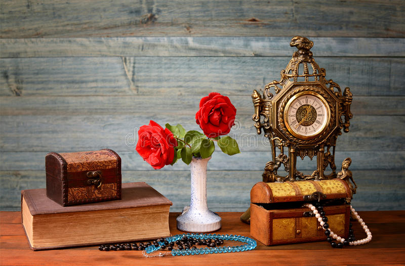 rosas-rojas-en-un-florero-un-reloj-y-una-joyería-51379553.jpg